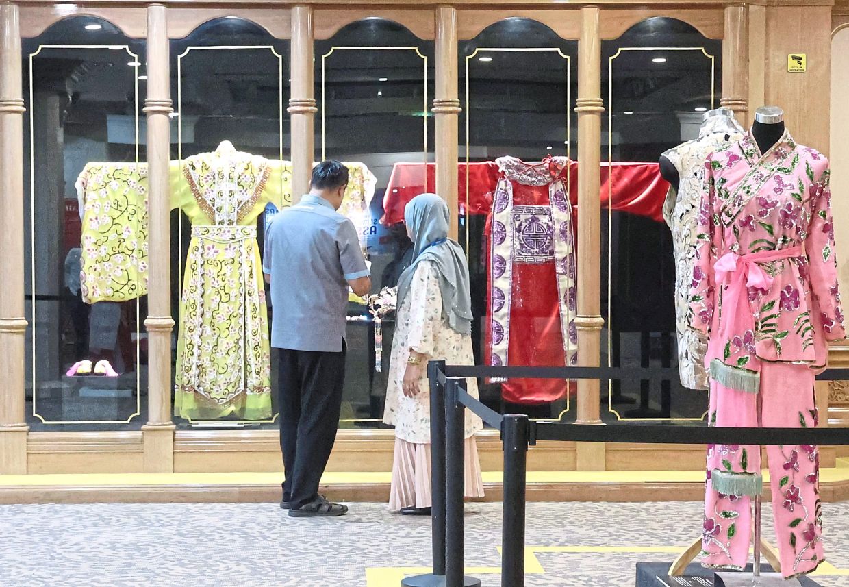 Visitors view Cantonese opera costumes (from left): Dai Hon Zong, Jyun Ling, and Mui Heung Saam. Photo: The Star/Art Chen