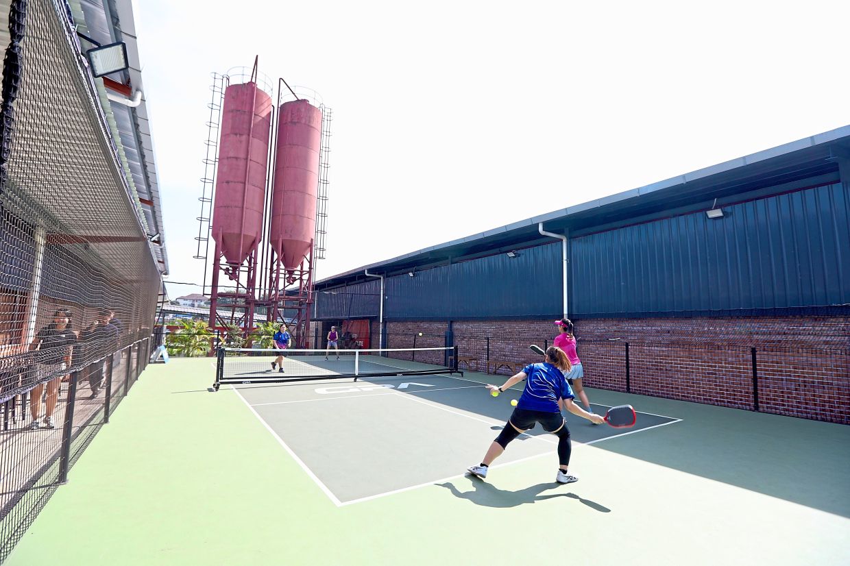 Pickleball enthusiasts playing a game at an outdoor court at Grand Pickleball Arena in Shah Alam.
