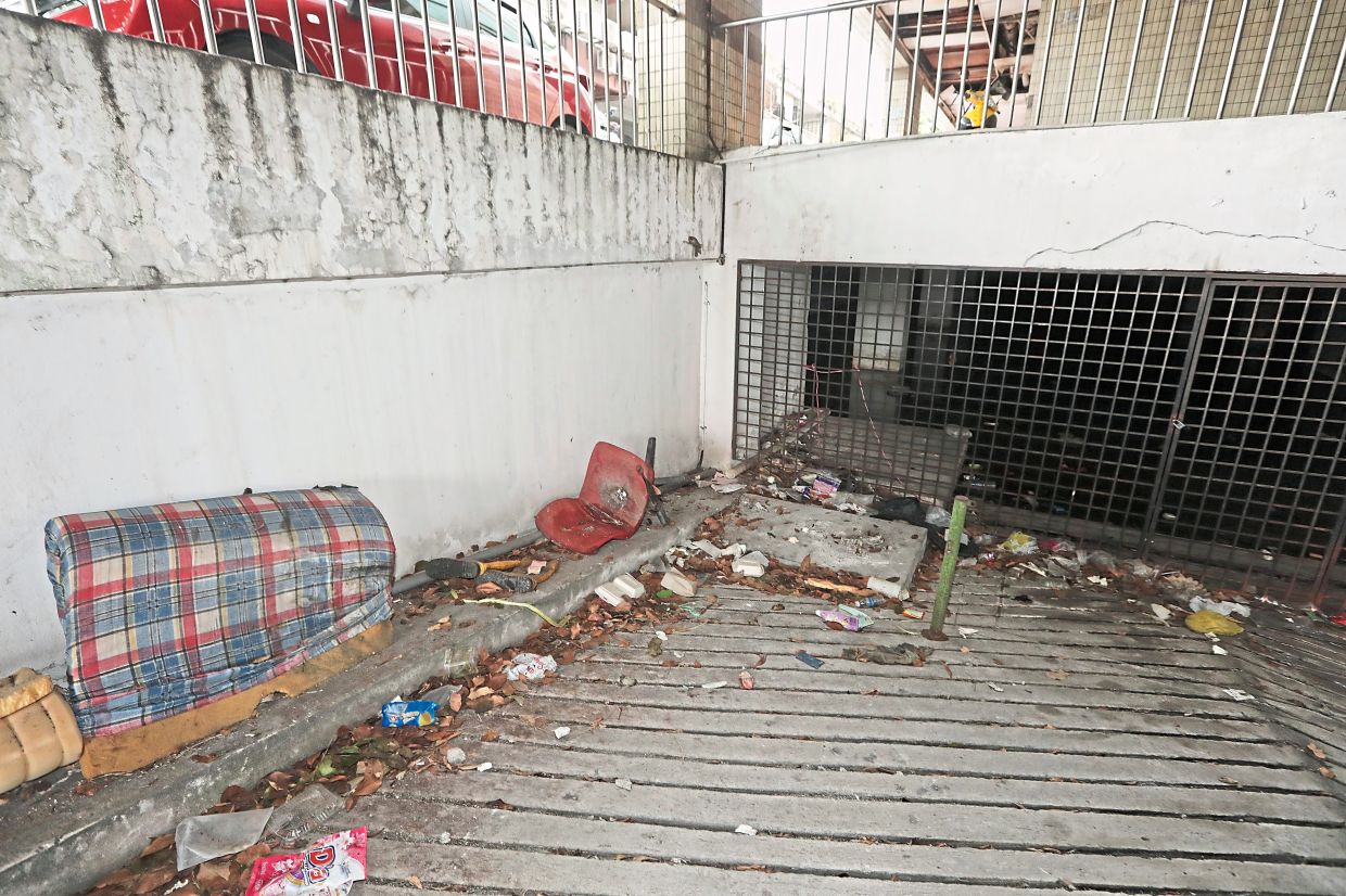 Discarded furniture and scattered rubbish at a ramp leading to the flooded basement carpark.