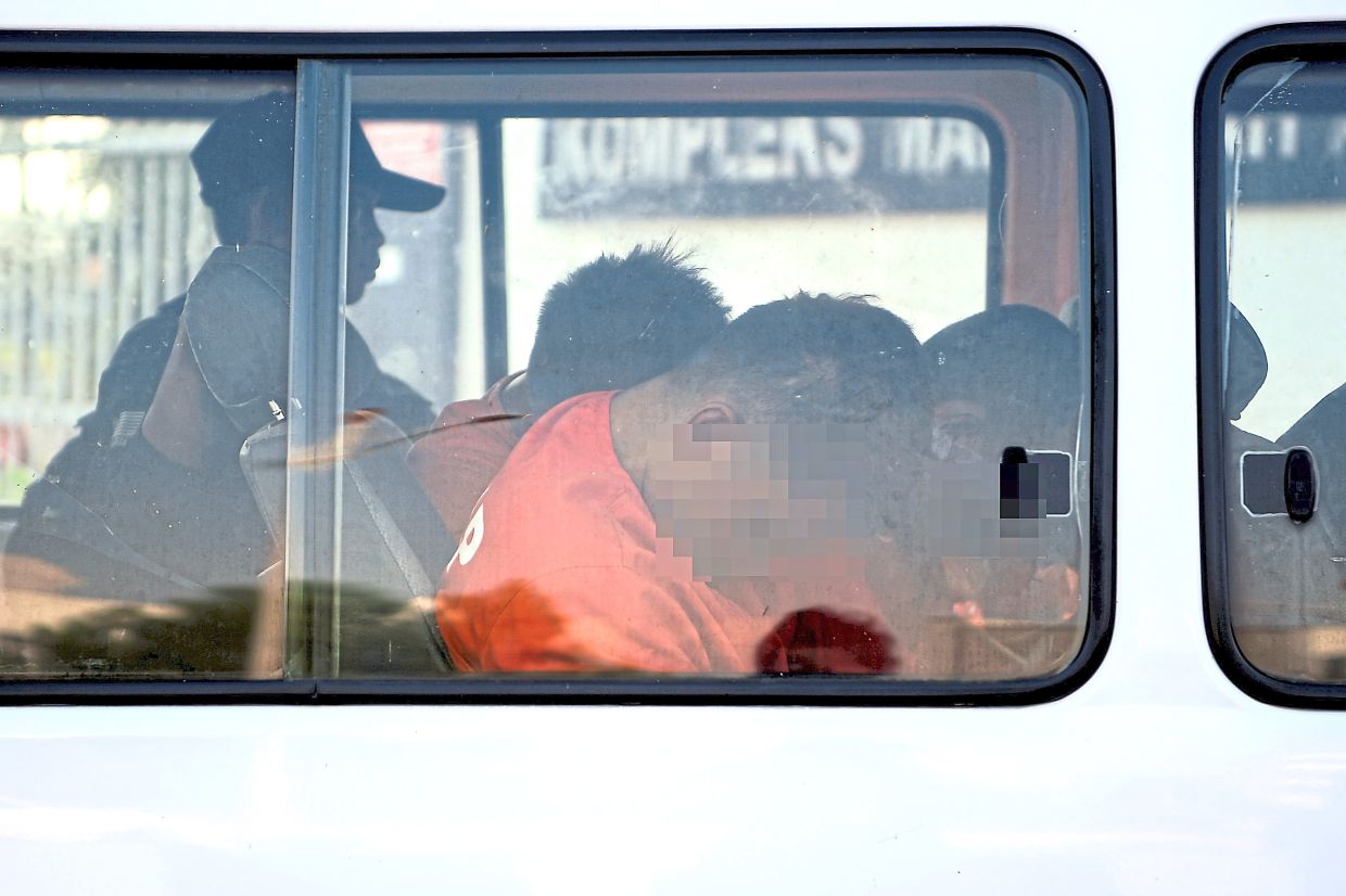 Heavy escort: The four suspects being taken to court.