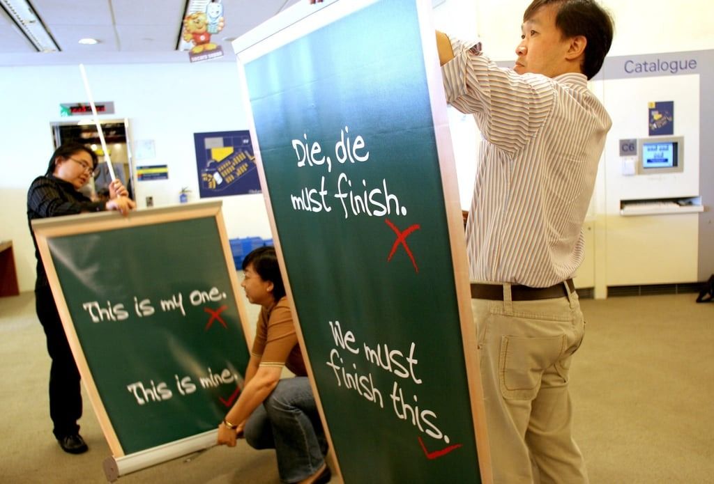 Library personnel set up standees that promote the use of correct spoken English in a library in 2006 in Singapore. The Speak Good English Movement, launched in 2000, discouraged the use of Singlish in favour of “Good English”.--Photo: AP