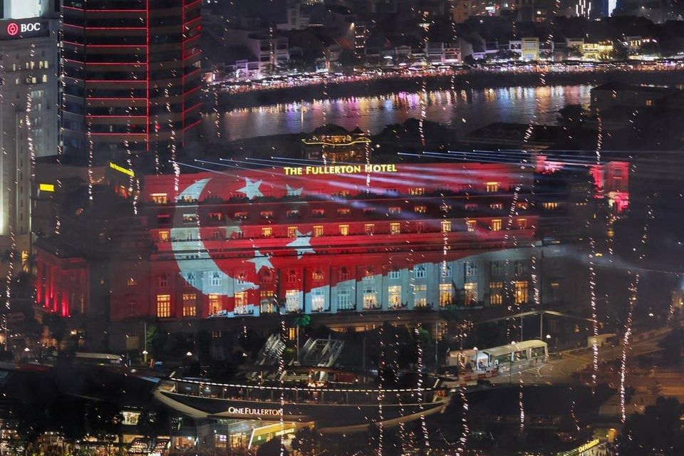 A light projection of the Singapore flag on the facade of The Fullerton Hotel on Aug 9. -- ST PHOTO: GAVIN FOO