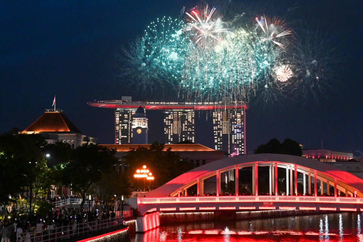 Fireworks illuminate the city skyline near the Sky Park observation deck of the Marina Bay Sands hotels (back C) during celebrations marking the country's 60th National Day in Singapore on Saturday, August 9, 2025. -- Photo by Roslan RAHMAN / AFP