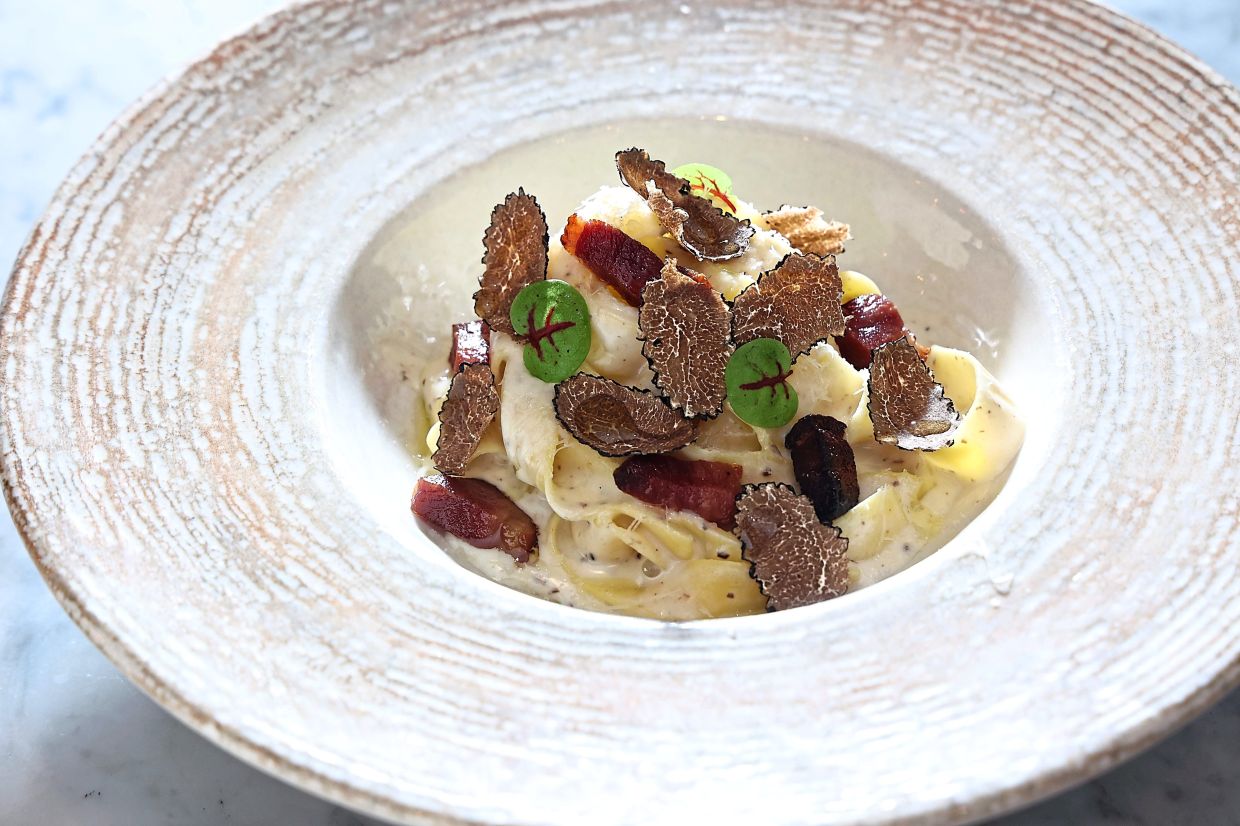 The handmade fettucine is enhanced with a cheese sauce and freshly shaved black Italian truffles.