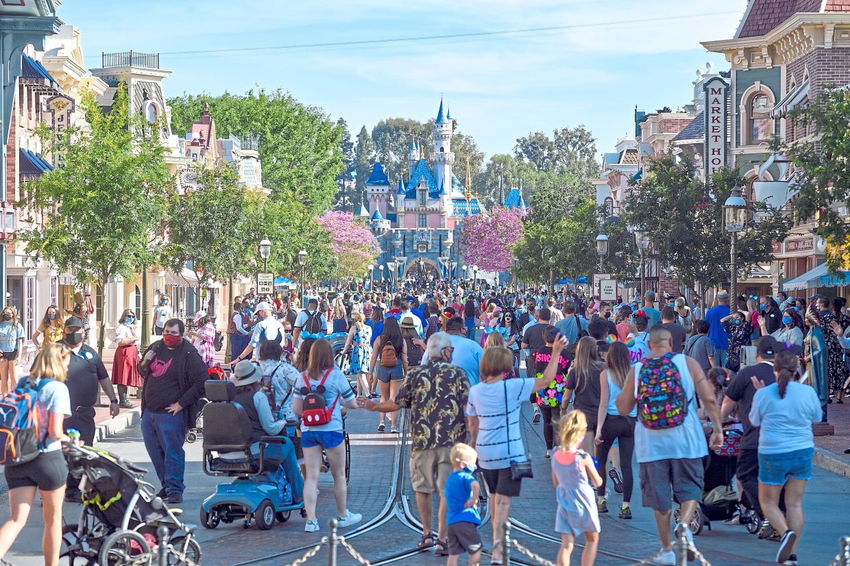 Visitors to Disneyland walk up Main Street USA just after the gates opened in Anaheim, California, on April 30, 2021. — JEFF GRITCHEN/Orange County Register/ZUMA/dpa