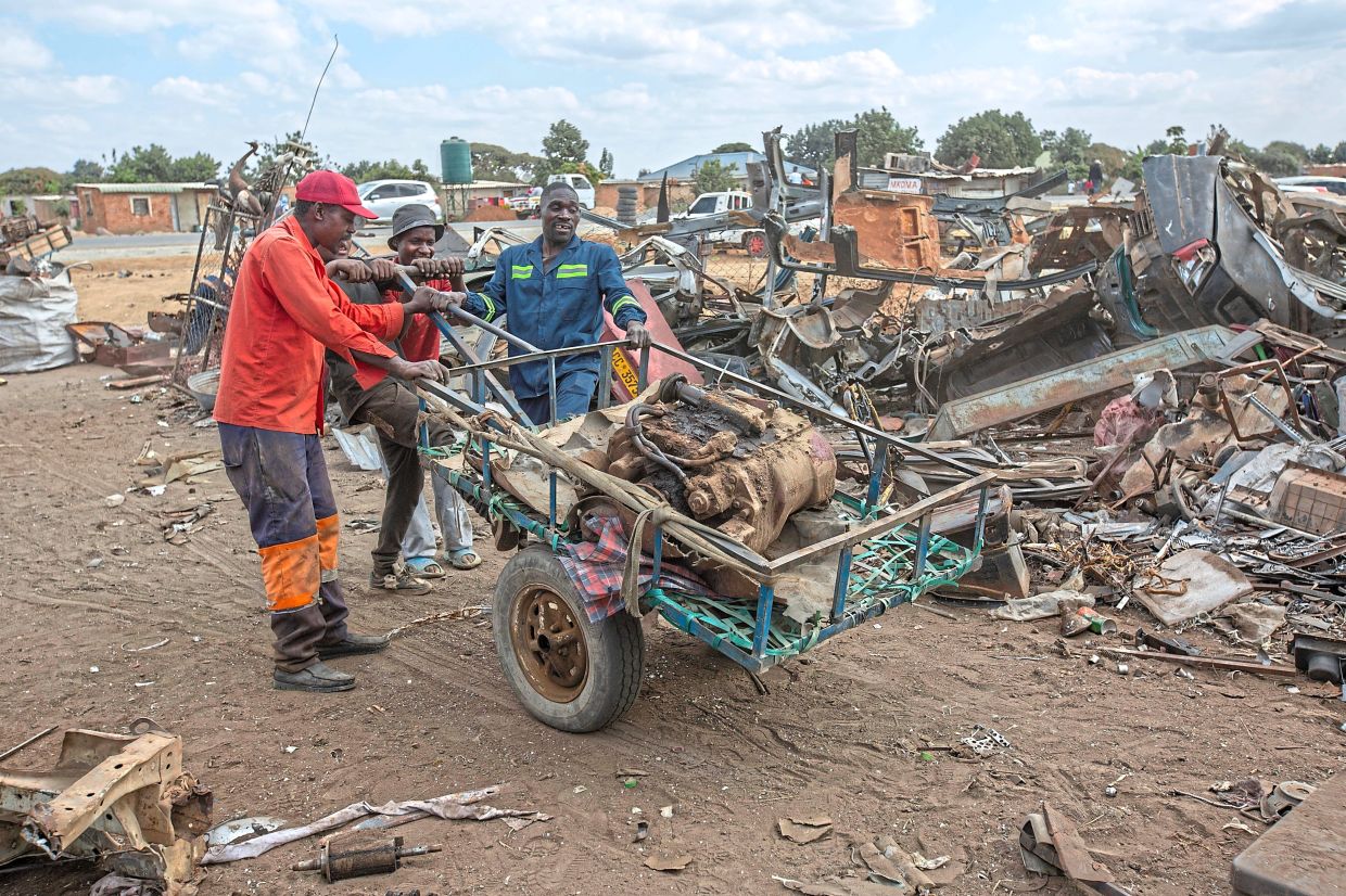 Scrap metal collectors move a piece.
