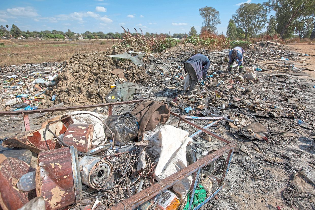 Men scrounge for scrap metal.
