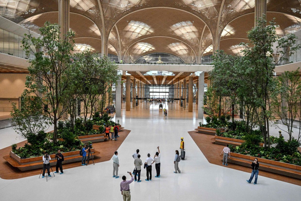 Journalists take photographs inside the newly built Techo International Airport in Cambodia's Kandal province on Monday, August 11, 2025. -- Photo by TANG CHHIN Sothy / AFP