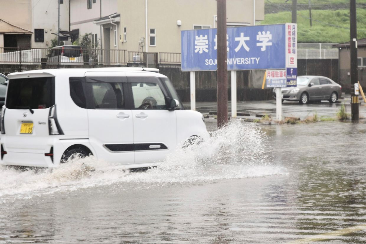 A vehicle advances through a flooded road in Kumamoto, southern Japan, on Monday, Aug. 11, 2025. - Photo: Kyodo News via AP