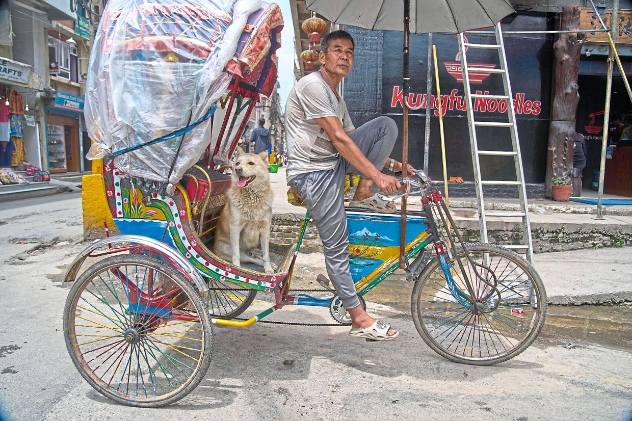 Tamang and his dog Shyam waiting for passengers in Thamel, a tourist hub in Kathmandu. 