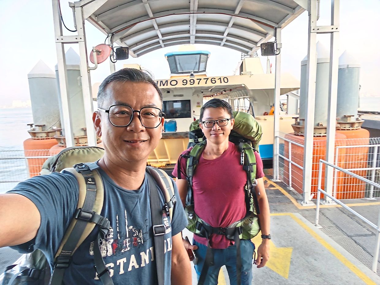 The writer(in red) and camper Kijohn Yeoh ready to get on board the new Penang ferry.