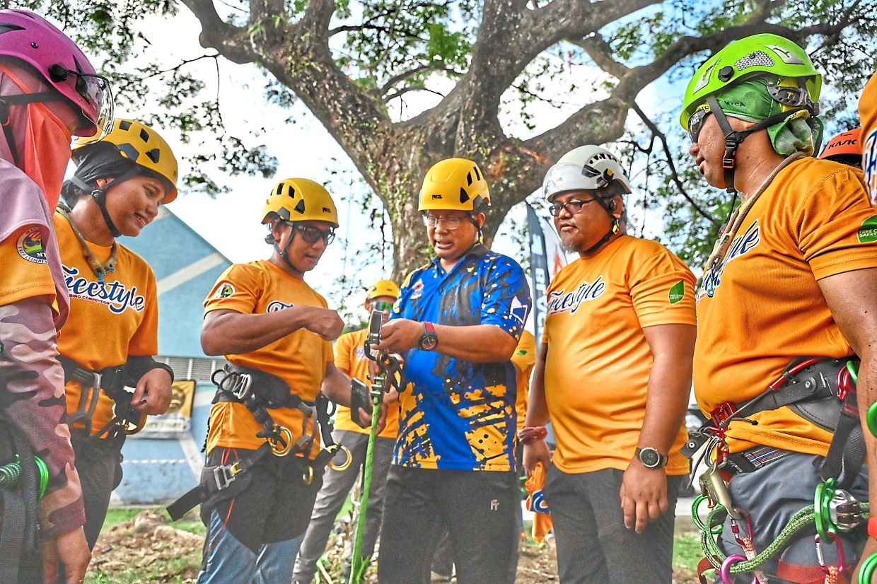 Mohamad Zahri (third from right) learning about tree climbing equipment at PJ International Outdoor Expo 2025 in Kelana Jaya. — Photos: RAJA FAISAL HISHAN/The Star