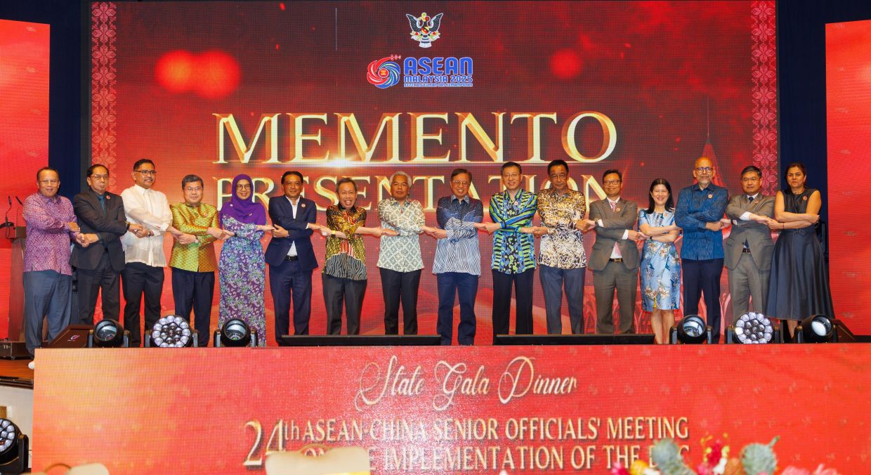 Sarawak Premier Tan Sri Abang Johari Openg posing for the Asean handshake with senior officers and delegates at the state gala dinner in Kuching. - ZULAZHAR SHEBLEE/The Star 