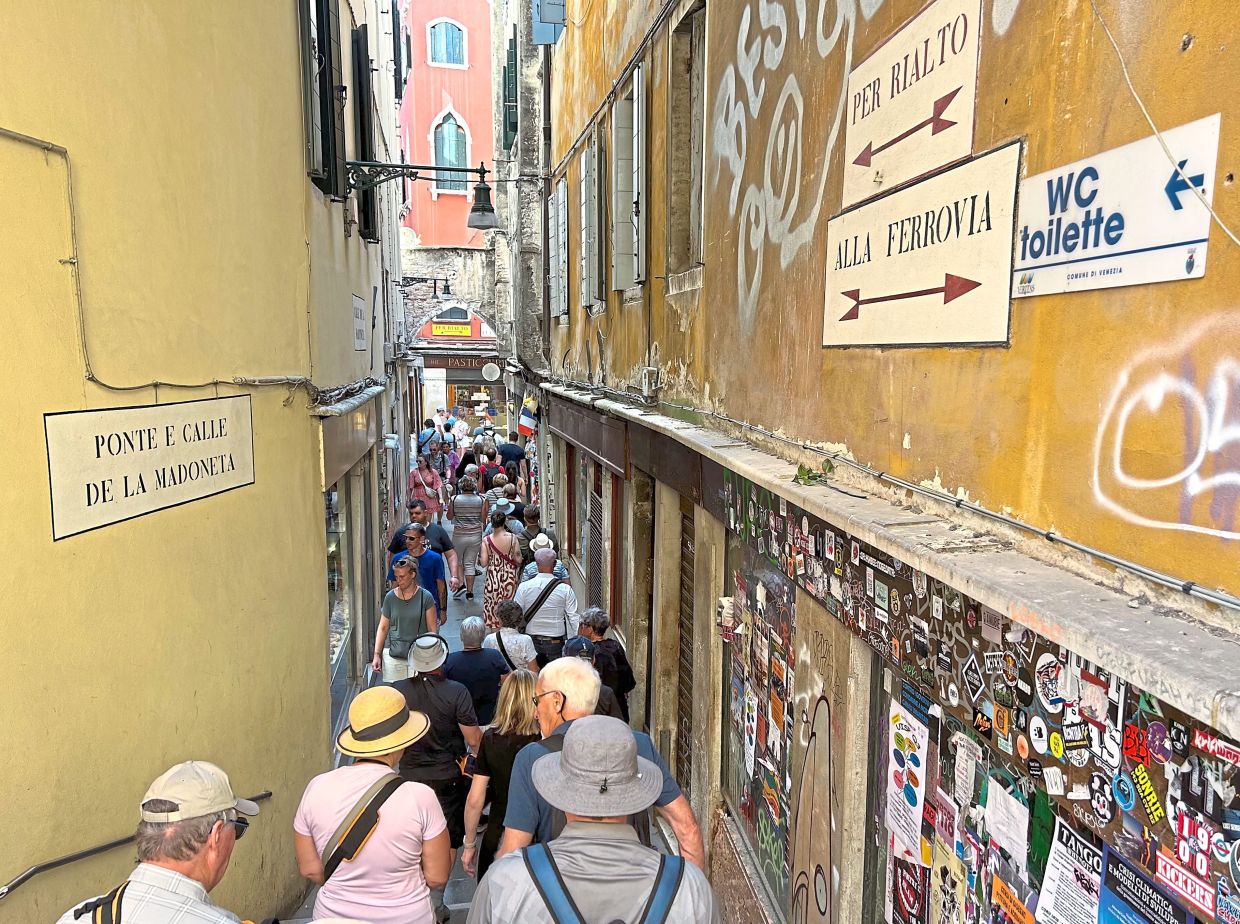 Visitors at one of the many narrow passageways in Venice.