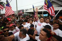 Umno Youth chief leads group of over 200 in march on barricaded shop lots