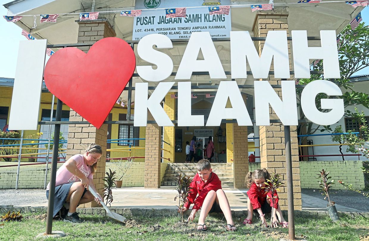 (from left) Charlotte Curnow, 12, Leon Wattie, nine, and Amelia Wattie, six, from Australia, planting shrubs at the SAMH grounds in Klang. — Photos: KK SHAM/The Star