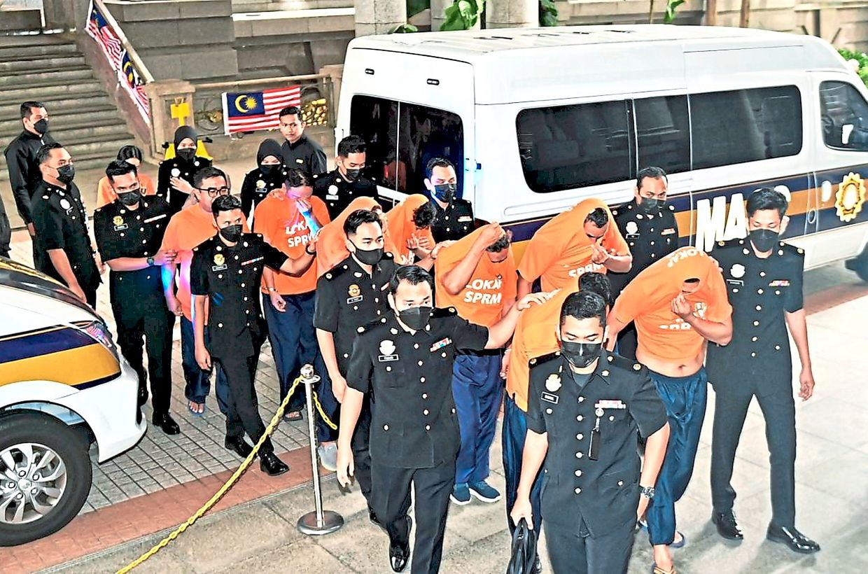 General orders: 10 individuals, including five senior armed forces officers, being escorted to the Putrajaya Magistrate’s Court.