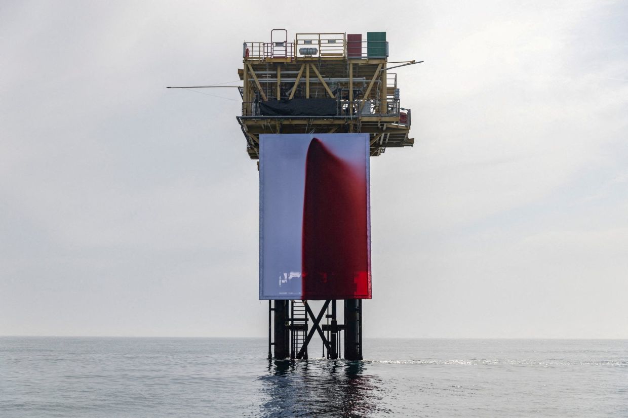 Renowned artist Anish Kapoor's work titled 'Butchered', installed by Greenpeace climbers, hangs from a Shell platform in the North Sea on Aug 13. Photo: Reuters 