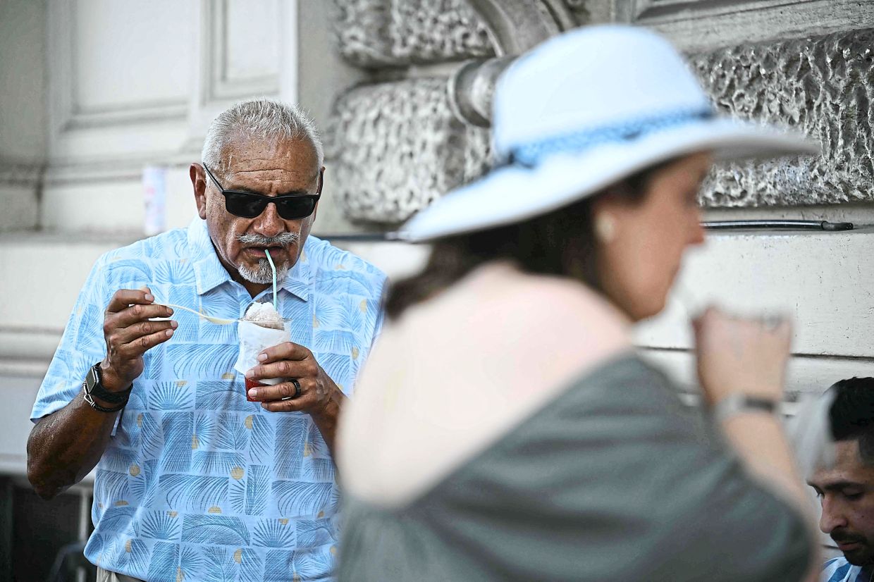 Customers eat a 'Grattachecca', or snow cones in Rome.
