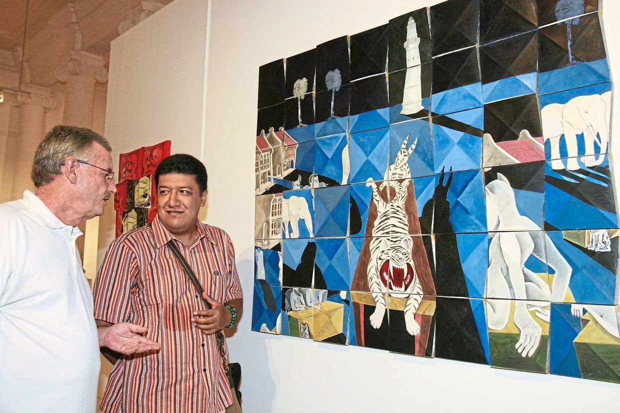 Tovar (right) and curator Unglehrt examine one of Tovar’s works in Penang, 2006. At Harta Space, Tovar co-curated the German-born artist’s tribute show. Photo: The Star/Filepic