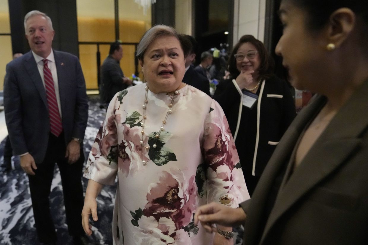 Philippine Foreign Secretary Theresa Lazaro, (centre) after attending a trade and investment conference at a hotel in Pasay, Philippines. -- AP Photo/Aaron Favila