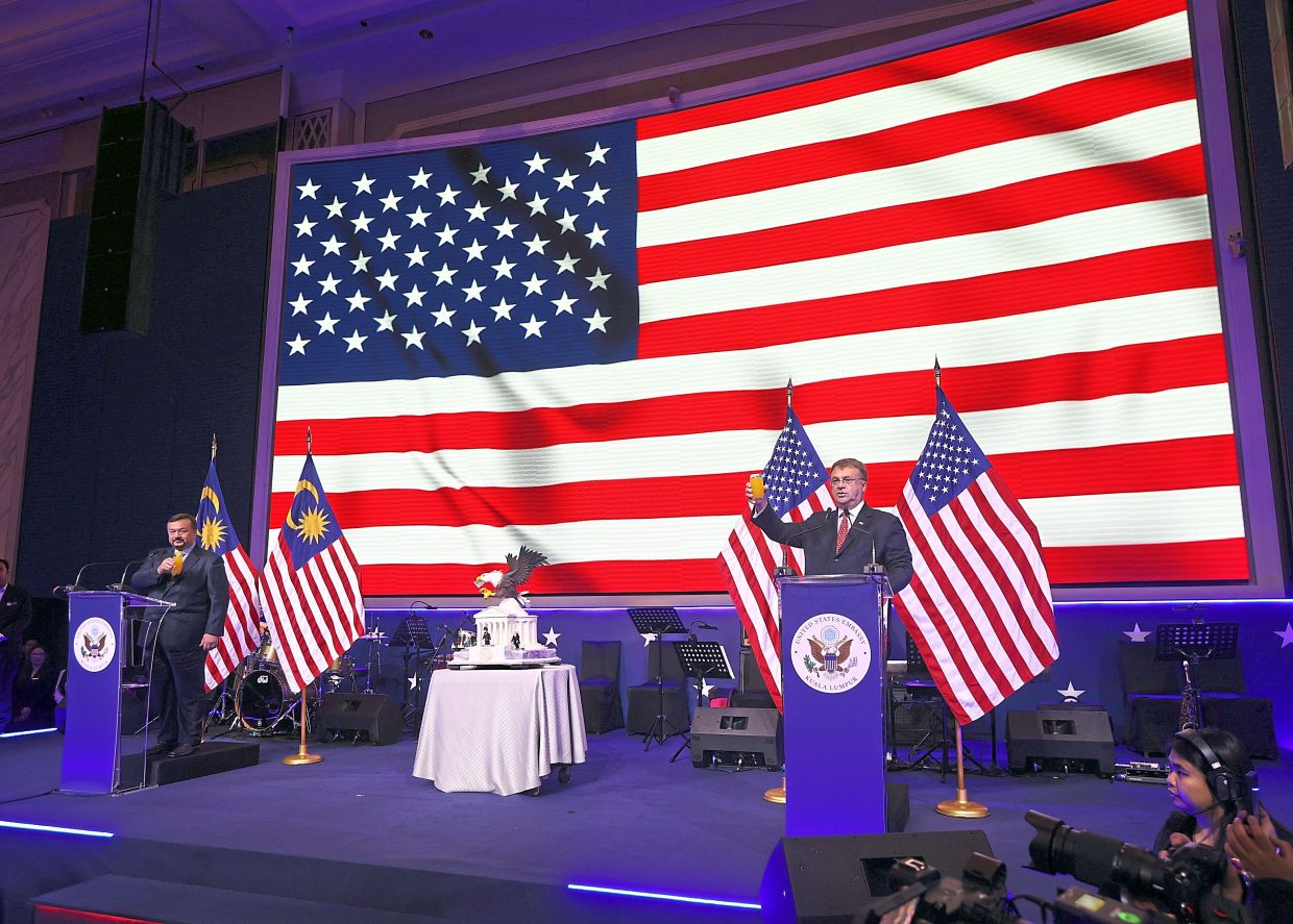 Kagan (right), with Amir Hamzah on stage, making a toast at the US Independence Day celebration in Kuala Lumpur.