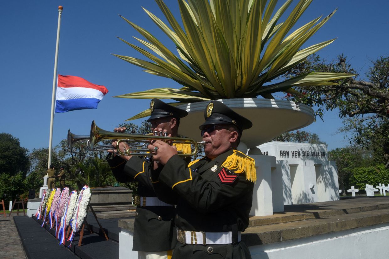 Indonesia's soldiers from the music corps play trumpets during a ceremony marking the 80th anniversary of the end of World War II, at the Ereveld Pandu cemetery, where Dutch soldiers who died in the war are buried in Bandung, West Java. --Photo by Timur Matahari / AFP