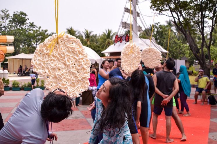 Contestants race to eat crackers without using their hands, a game rooted in a time when crackers were a survival staple. - Photo: The Jakarta Post/ANN