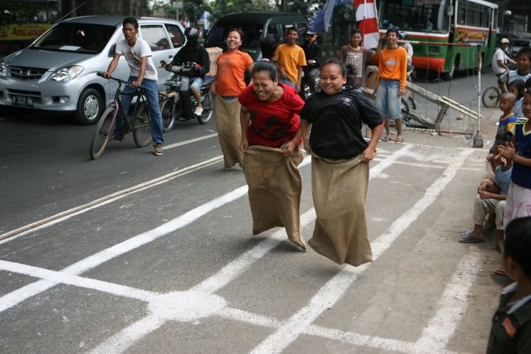 Racers leap forward in a sack race, a game rooted in the scarcity of wartime Indonesia. - Photo: The Jakarta Post/ANN