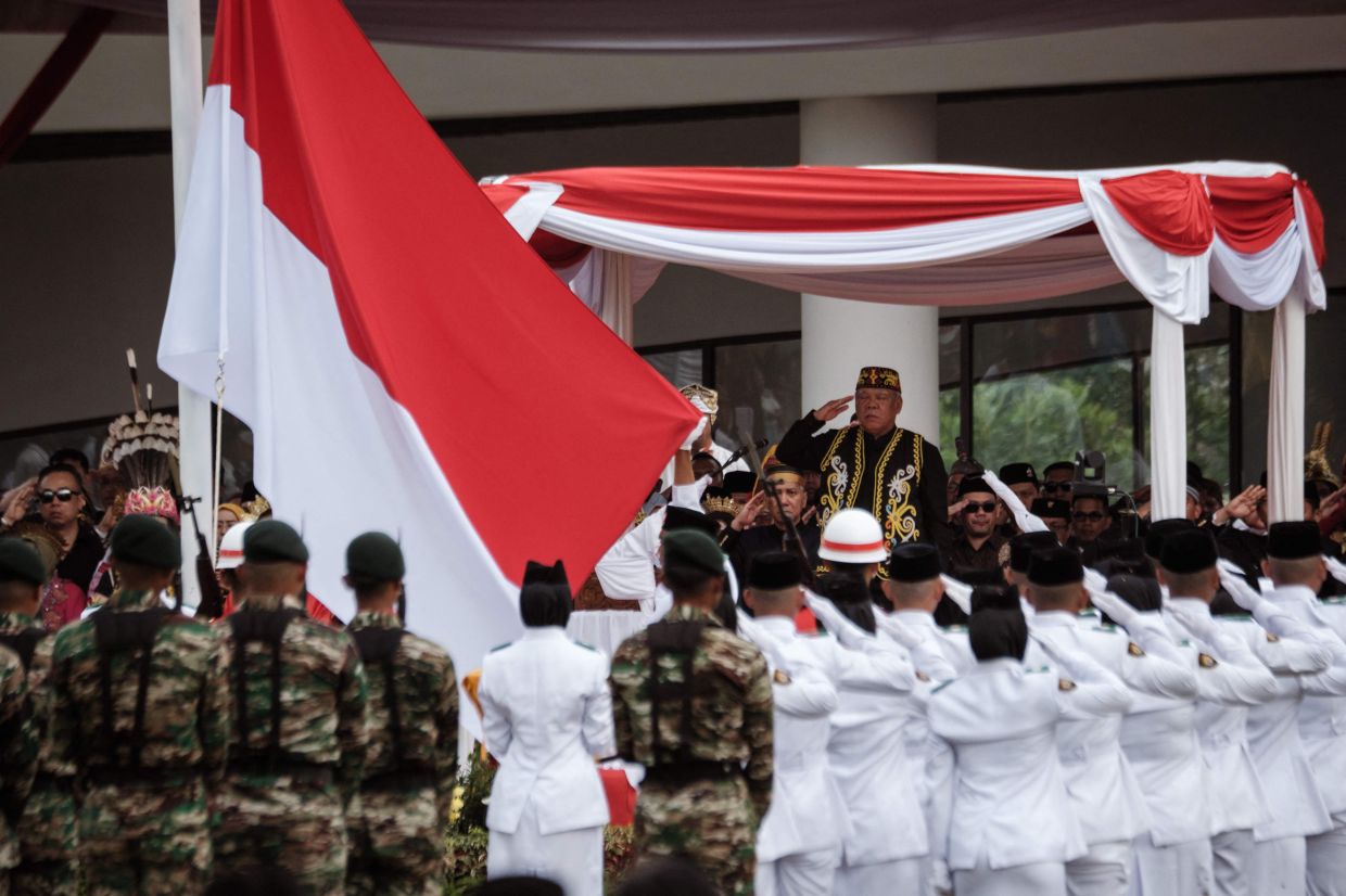 Basuki Hadimuljono, head of the Nusantara Capital City Authority, salutes the national flag during a ceremony marking Indonesia's 80th Independence Day at the Ceremonial Plaza in Indonesia's future capital, Nusantara, in East Kalimantan on August 17, 2025. -- Photo by Yasuyoshi CHIBA / AFP)
