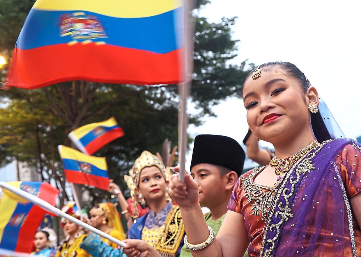 Cutie pies in traditional outfits waving Federal Territories flags. — Photos: AZMAN GHANI/The Star