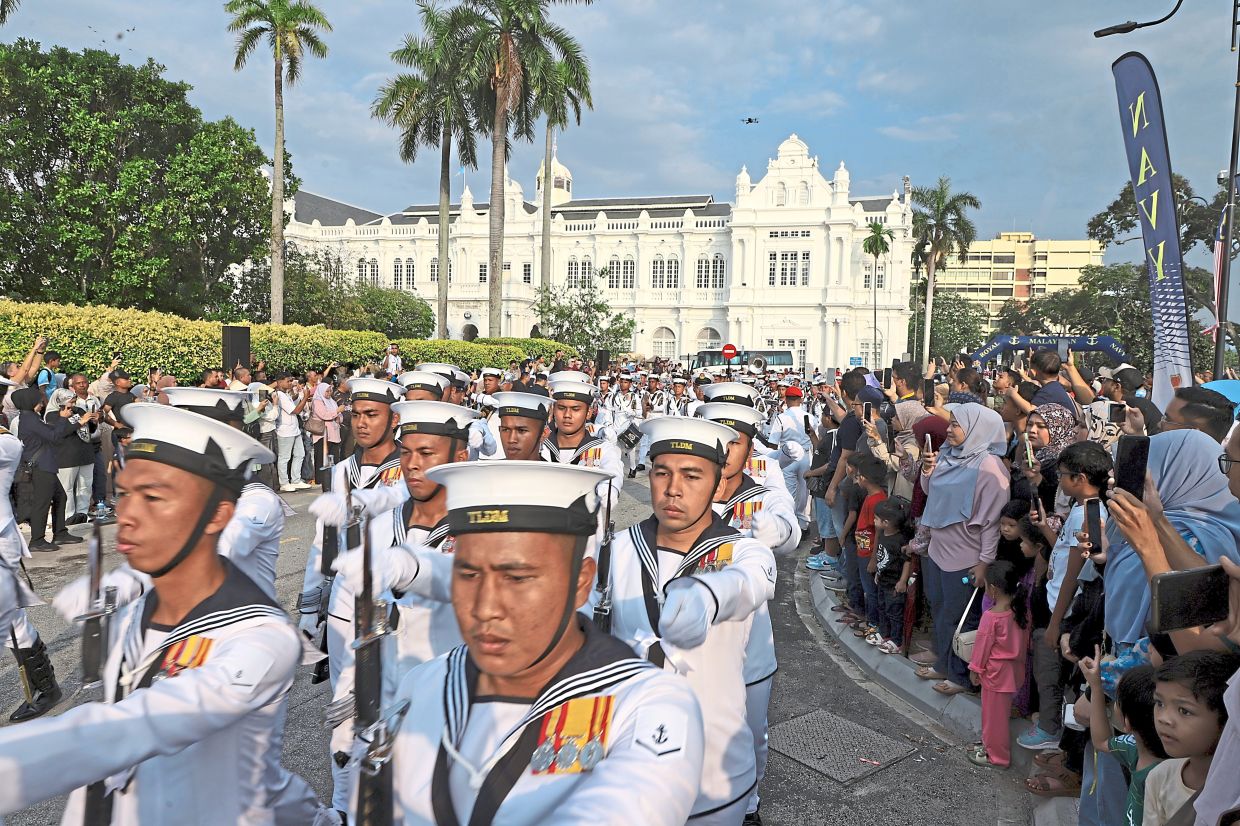 The crowd cheering as TLDM officers march in formation along Jalan Padang Kota Lama for the Asean Navies’ City Parade in George Town. — LIM BENG TATT/The Star