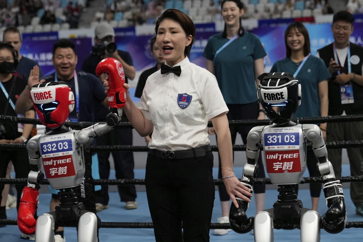 A referee announces the winner of a Free Combat event during the World Humanoid Robot Games held in Beijing, China, Saturday, Aug. 16, 2025.