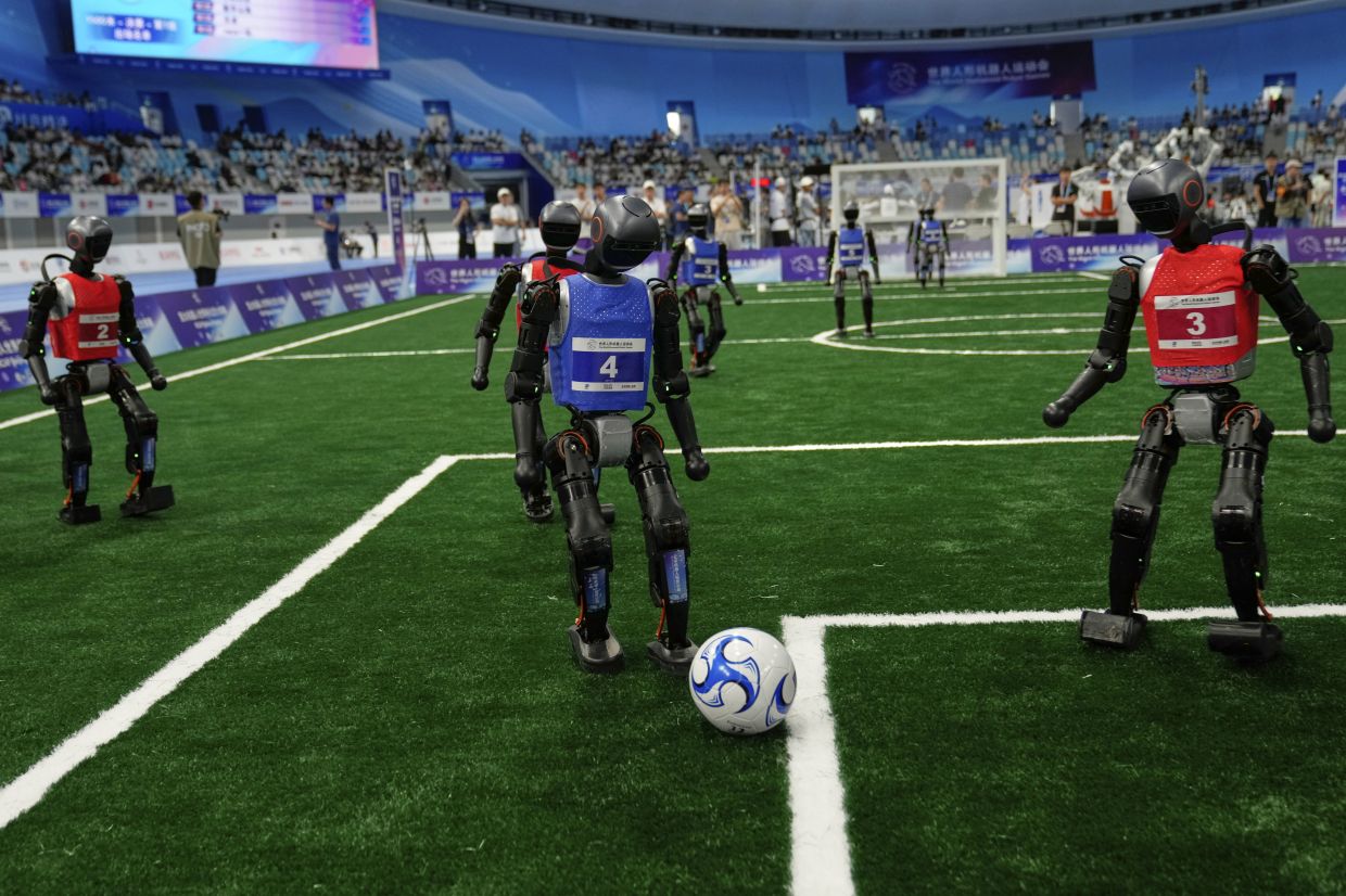 Robots play soccer at the World Humanoid Robot Games in Beijing, China, Friday, Aug. 15, 2025.