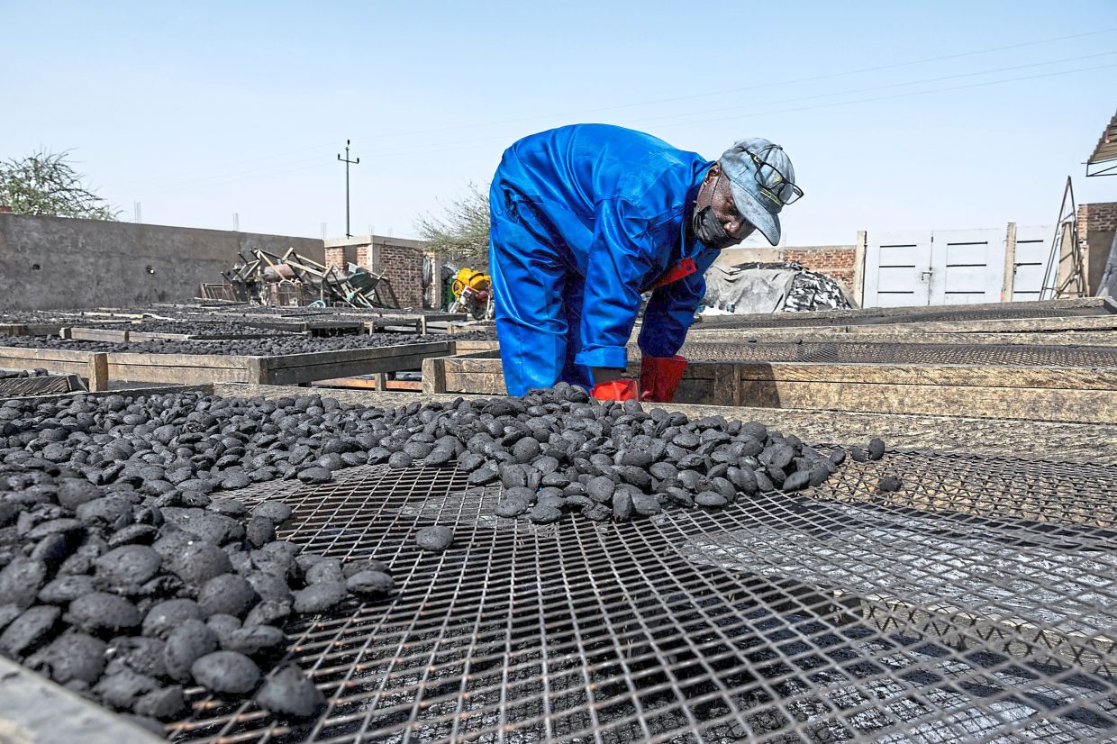 A worker dries coal pebbles at Grace International’s coal production site in N’Djamena, Chad. — Photos: AFP