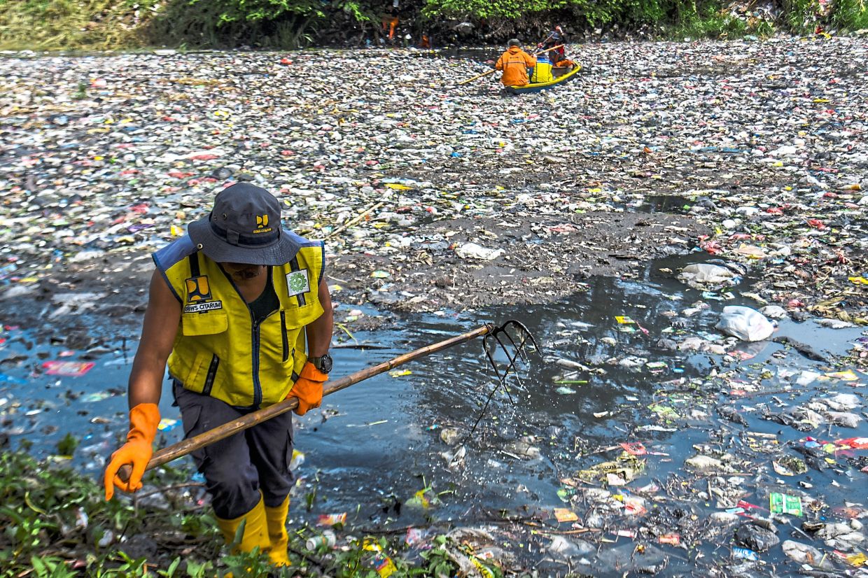 Workers removing rubbish in Java’s Citarum River. — DIMAS RACHMATSYAH/Zuma Press Wire/dpa