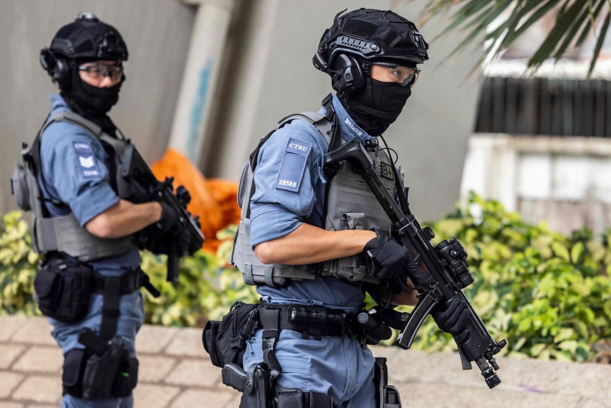 Armed police officers stand guard outside the West Kowloon court after Hong Kong media mogul Jimmy Lai arrived for his national security trial in Hong Kong on Monday, August 18, 2025. --Photo by ISAAC LAWRENCE / AFP