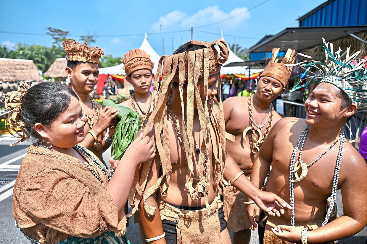 Temuan tribe members getting ready to perform a traditional dance.