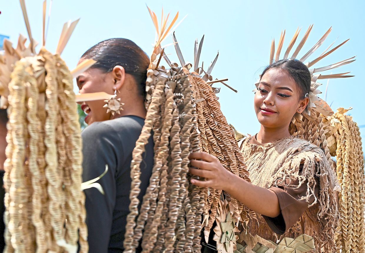 Mah Meri women with elaborate hair accessories crafted from natural materials, reflecting their deep connection to the environment and rich cultural heritage.