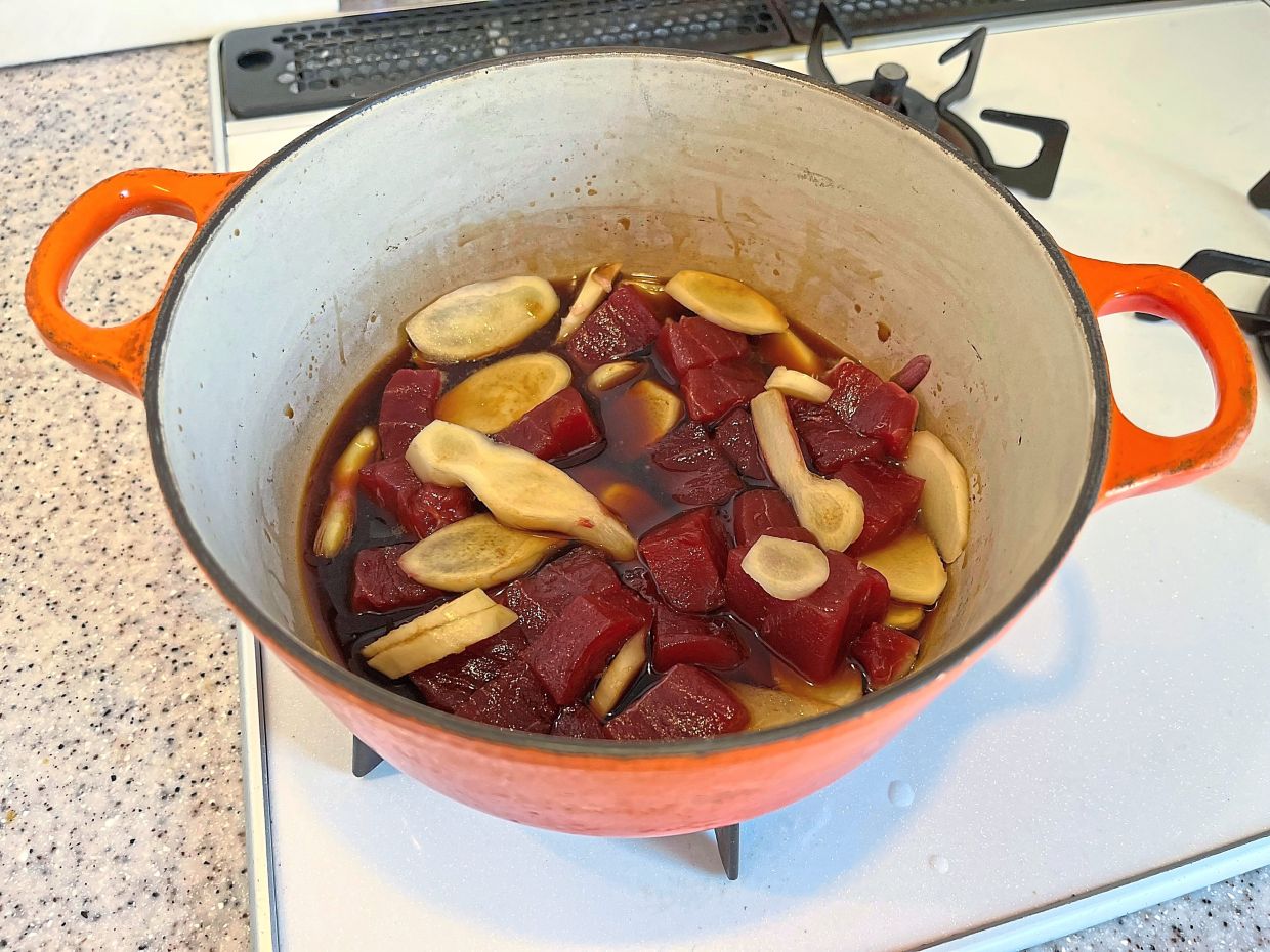 Chopped tuna and sliced ginger simmer in a sauce consisting of soy sauce, mirin, sake, sugar and salt to make tsukudani.