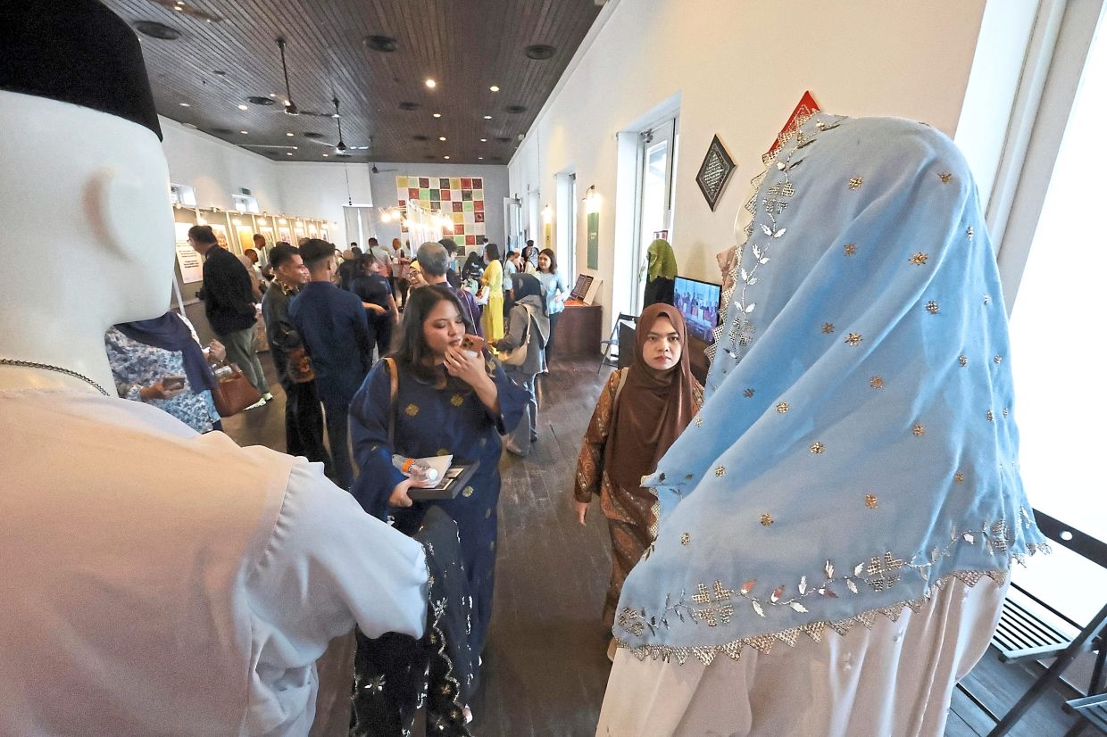 Visitors admiring a keringkam headscarf at the exhibition in conjunction with the Aspire graduation ceremony.