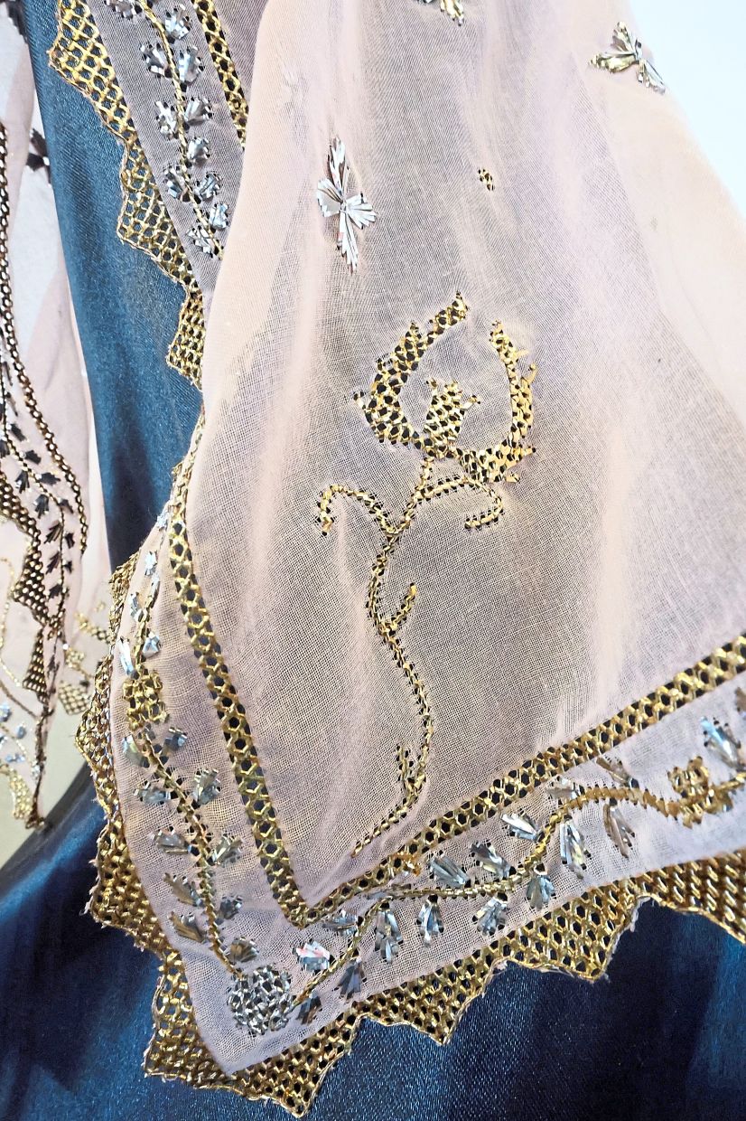 A keringkam piece produced by an Aspire trainee featuring an intricate floral design in gold thread.