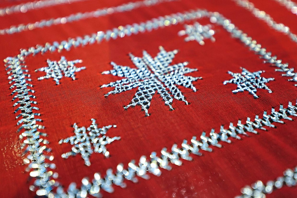 A keringkam piece featuring the tali air kaki lipan (centipede legs) border and a floral motif. - ZULAZHAR SHEBLEE/The Star