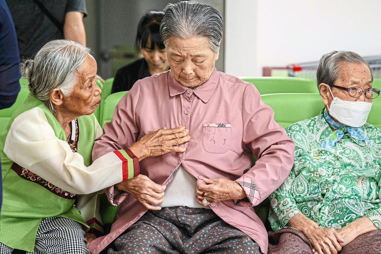 This photo taken in Hapcheon, South Gyeongsang, about 320 kilometres south of Seoul on July 10, 2025 shows residents preparing to have their portraits taken for use at their funerals at the Hapcheon Atomic Bomb Victim Welfare Center, opened in 1996 by the Korean Red Cross with funding from both South Korean and Japanese governments, providing round-the-clock service to survivors of the World War II atomic bombings seeking help. Some 740,000 people were killed or injured in the twin bombings of Hiroshima and Nakasaki which ended World War II -- and more than 10 percent of the victims were Korean, data suggests, the result of huge flows of people to Japan while it colonised the Korean peninsula. (Photo by Anthony WALLACE / AFP) / To go with Japan-SKorea-history-nuclear,FOCUS by Harumi Ozawa and Kang Jin-kyu