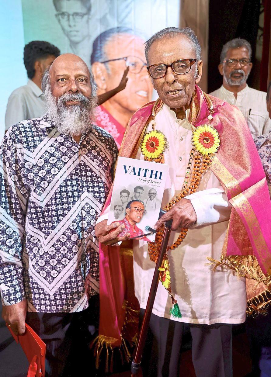 Kathirasen (left) with Vaithilingam holding his biography. — LOW BOON TAT/The Star