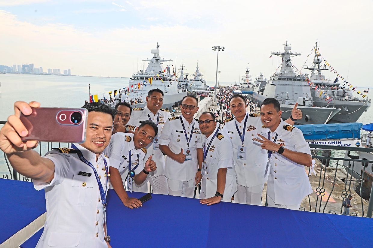 RMN personnel taking a wefie with Asean warships lining both sides of Swettenham Pier Cruise Terminal.