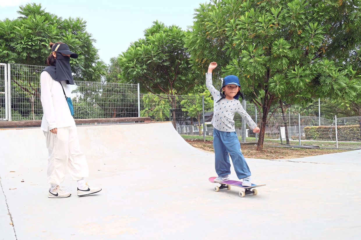 Chen (left) watching over her son who started to learn skateboarding at the skate park of Johor Baru TMIYC.