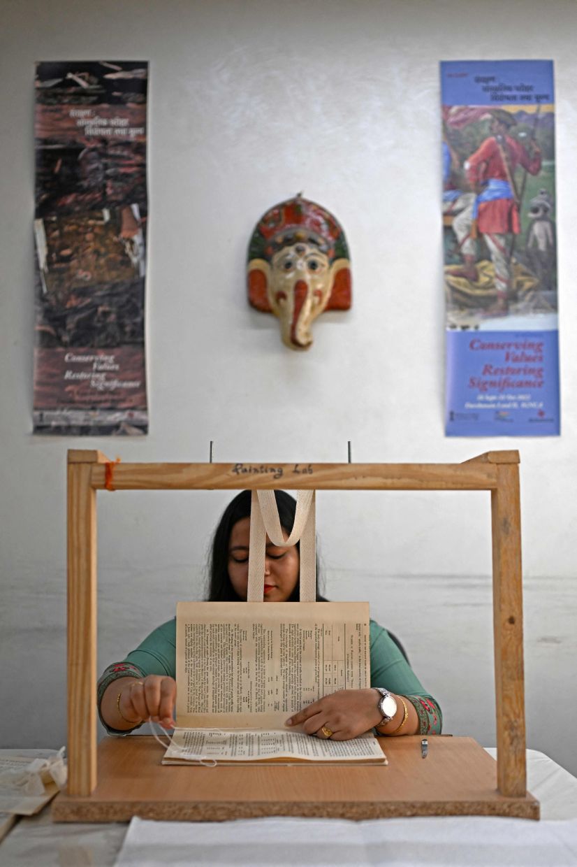 An employee sewing a book inside the paper conservation lab of the conservation department at the Indira Gandhi National Centre for Arts (IGNCA), in New Delhi. Photo: AFP 