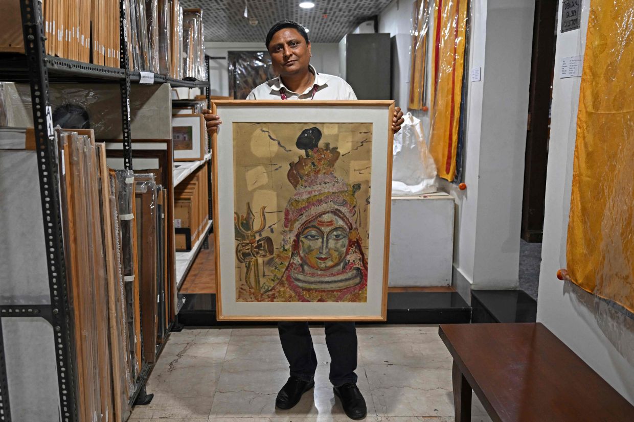 Achal Pandya, head of the conservation lab holding a painting from the collection of Elizabeth Brunner's storage at the conservation department of the Indira Gandhi National Centre for Arts (IGNCA), in New Delhi. Photo: AFP