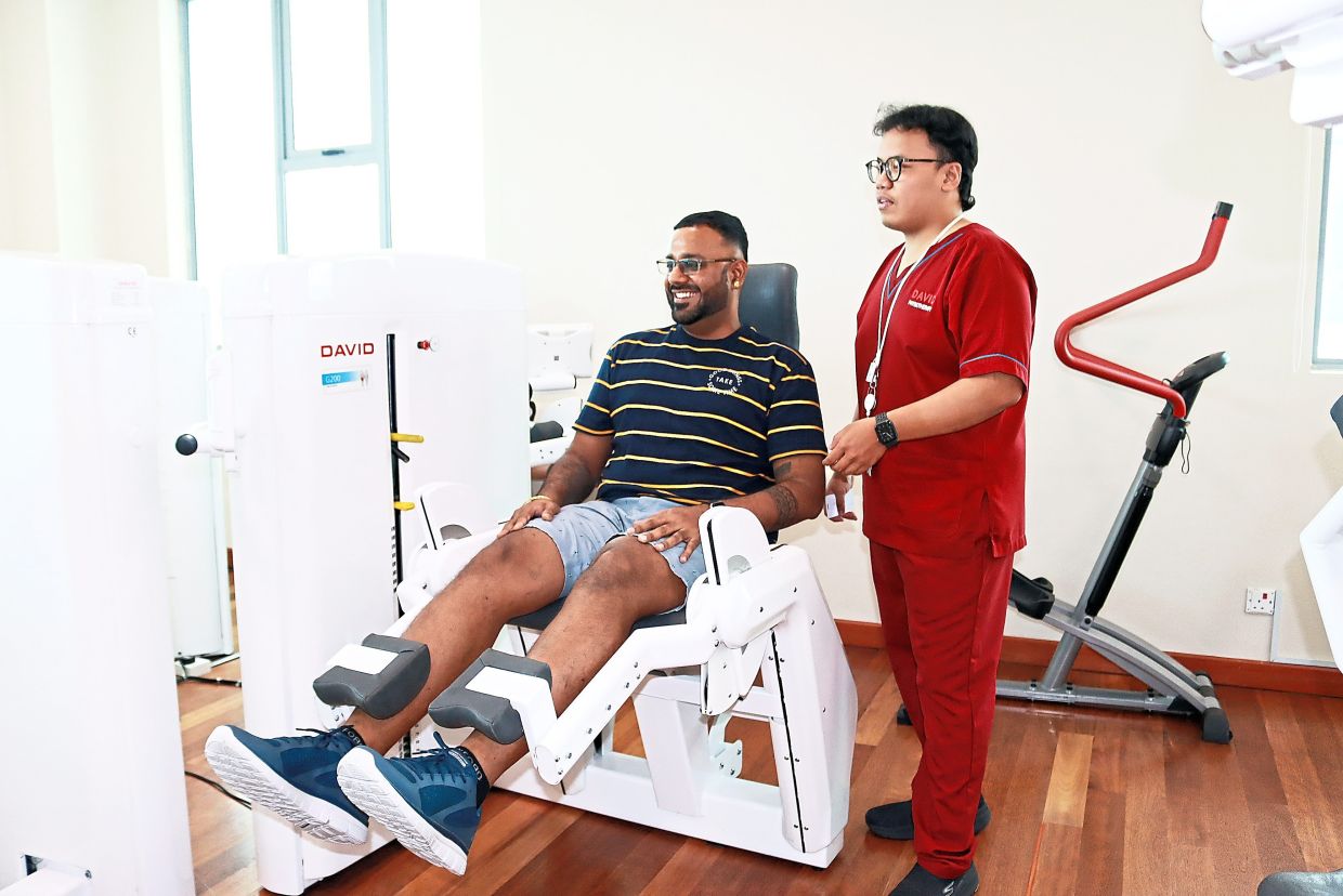Karthikeyen demonstrates an AI-guided physiotherapy exercise, as his colleague Muhammad Amir Zakwan Mohd Zamri monitors him. — Bukit Tinggi Medical Centre